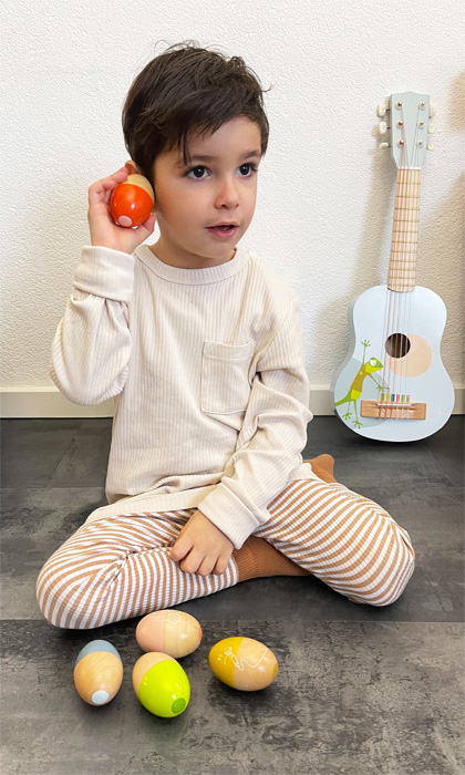 Bambino che gioca con uova musicali in legno Legler
