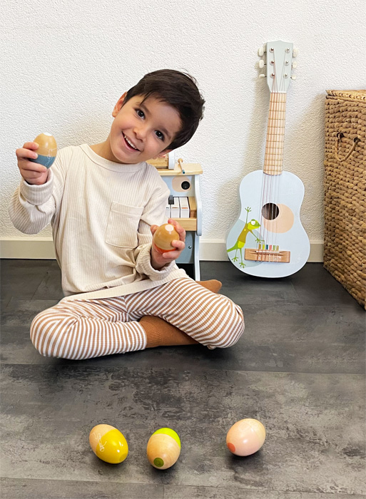 Bambino che utilizza uova musicali in legno Legler